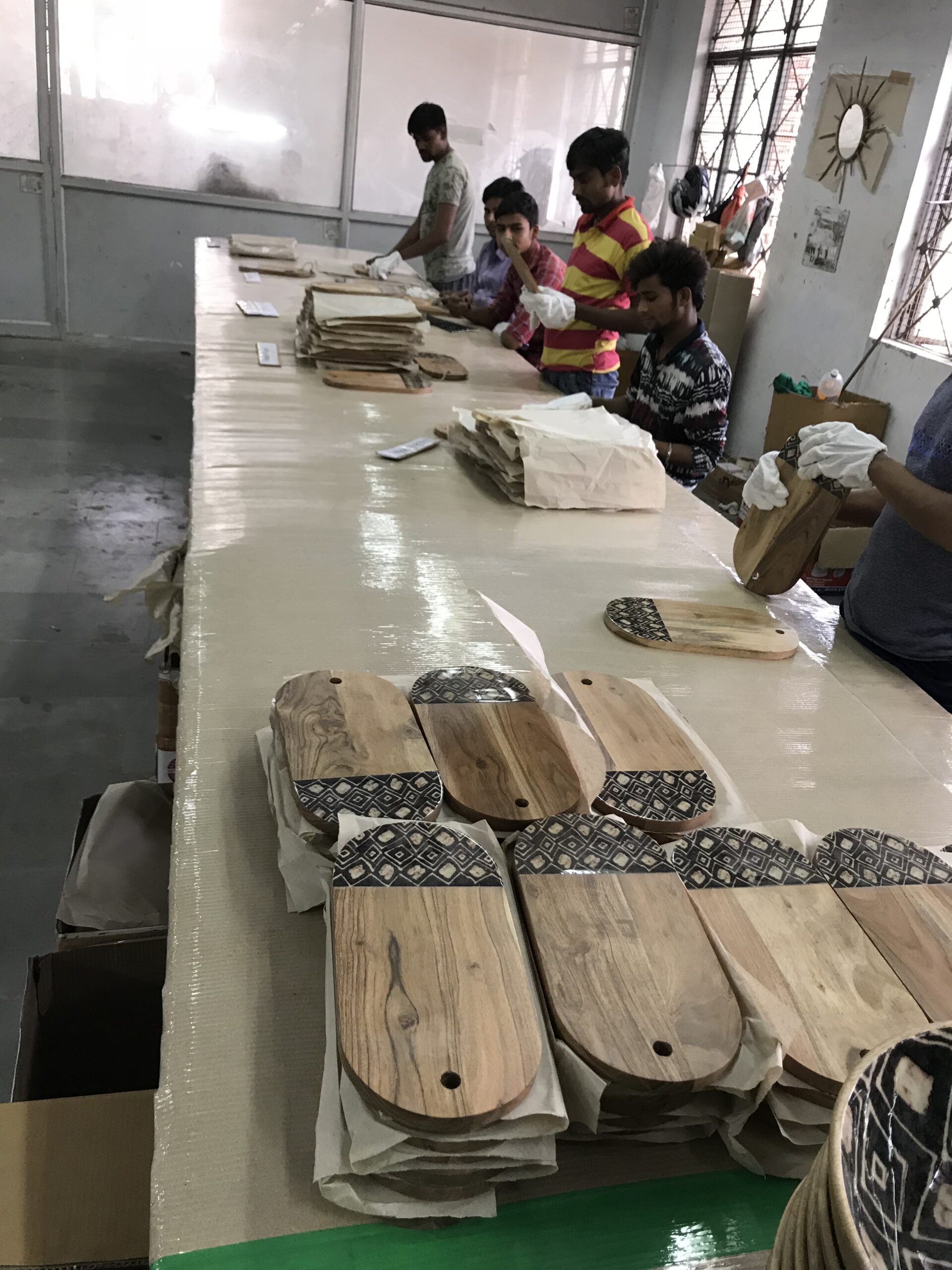 Quality Control inspections taking place in India on a wood and enamel serving board